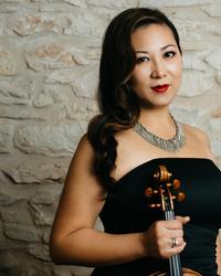 A woman wearing a black dress holding a violin